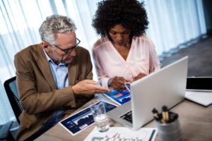 Two professionals analyzing sales data and charts during a meeting, highlighting the importance of CRM integrations.